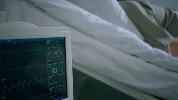 老人病院に寝そべっている病院の部屋で 彼は脈拍を示す心拍数モニターパルス酸素濃度計を指で測定した Arriで撃たれた — ストック動画