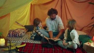 Bir baba, oğullarıyla birlikte gülerek ve kitap okurken rahat görünen modern bir çarşaf kalesinde çok iyi vakit geçirir. 4k