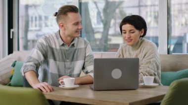 Kahve dükkanındaki çekici çiftin önünde laptopta bir şeyler analiz edip kahve içerken tartıştılar. 4k
