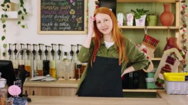 Küçük işletme kavramı ve kahve dükkanında müşteriyi beklerken dans eden sevimli gülüşlü baristalı güzel bir girişimci. ARRI Alexa Mini 'de çekilen.