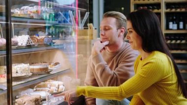 Modern fırın kafeteryasında çok güzel görünümlü çiftler en sevdikleri tatlıları buzdolabından seçiyorlar. 4k