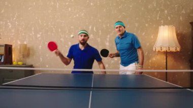 Karizmatik yaşlı adam ve oğlu birlikte pinpon oynuyorlar topa raketlerle vuruyorlar ve heyecanlılar. ARRI Alexa Mini 'de çekilen