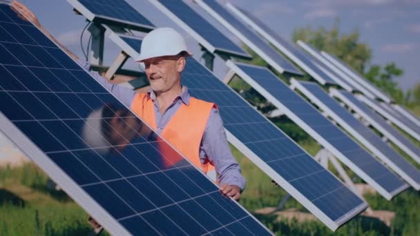 Happy Concentrated Man Engineer Trouncing Photovoltaic Solar Panels Analysing Cleanliness — Stockvideo