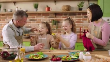 Mutfak adasında kameranın önünde çok aydınlık güzel ve karizmatik bir aile sabah okula gitmeden önce sağlıklı bir kahvaltı yaparlar. 4k