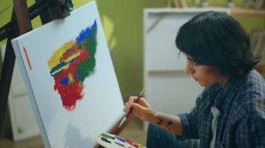Bir kadın çok yoğunlaşmıştır ve ressam ortamında tuvaline çok parlak olan bir çok gözü cezbeden bir şey çizmektedir. ARRI Alexa Mini 'de çekilen