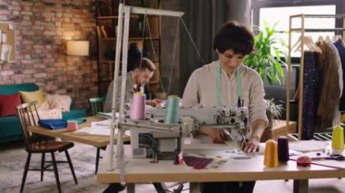 İki terzi bir ev ofisinde tasarım ve iş yapıyorlar ve işlerini birlikte yapmaktan çok memnun görünüyorlar. ARRI Alexa Mini 'de çekilen