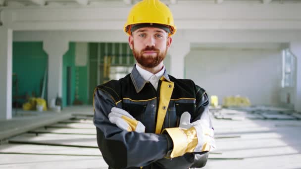 有魅力的建筑工人穿着特殊制服 头戴安全帽 在建筑工地的摄像机前摆姿势 — 图库视频影像