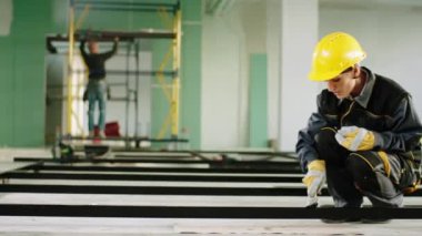 İnşaatta geniş bir bina. Karizmatik kadın müteahhit olarak çalışıyor. Güvenlik kaskı ve özel üniforma taktığı inşaat malzemelerini fırçayla boyuyor. 4k