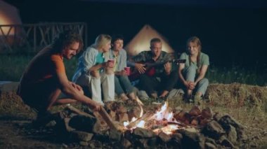 Gece grup halinde çok karizmatik çok karizmatik arkadaşlarla birlikte yangın kazığının yanında oturmuş gitar çalıyor ve şarkı söylüyorlardı. 4k