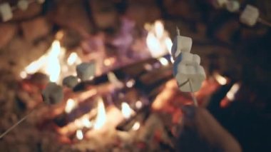 Ateş kazığı grubunun yanında elinde lokumlar olan insanlar onları ateşe atıp eritiyor..