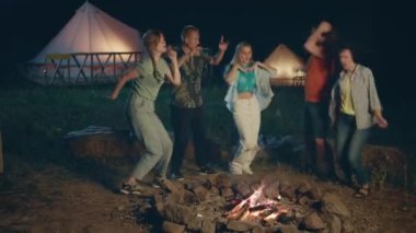 Gece vakti, çok ırklı bir grup öğrenci kamp alanında birlikte vakit geçiriyorlar. Kazığın yanında dans ediyorlar, şarkı söylüyorlar ve rahatlıyorlar. 4k