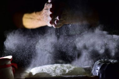 man's hands with flour on black background. concept of the kitchen, baking at home