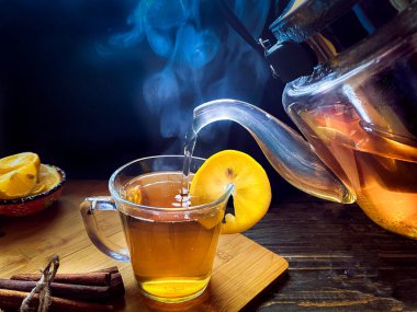hot tea with lemon and cinnamon on a wooden background