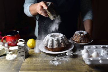 close up of a chef decorates homemade cake with sugar powder