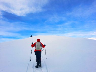 man with backpack climbing on top of the mountain