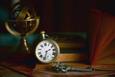 old vintage clock and books on dark background