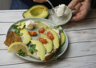man making delicious fresh toasts with avocado, tomatoes and cheese