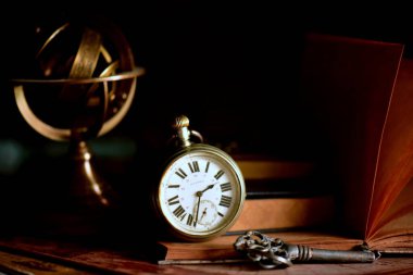 old vintage clock and books on dark background