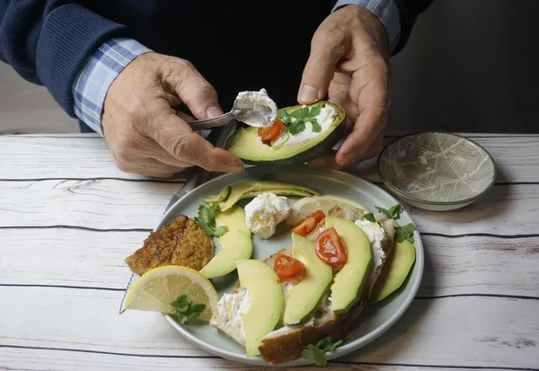 man making delicious fresh toasts with avocado, tomatoes and cheese