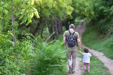 Genç baba ve kızı yolda yürüyor.