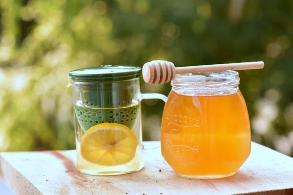 honey and lemon water on a wooden table