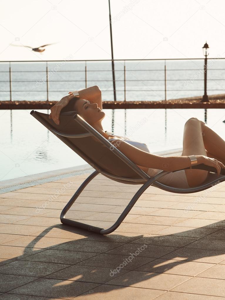 Beautiful girl lying on a sun lounger