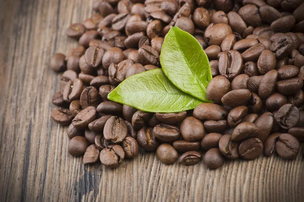 Granos de café sobre mesa de madera —  Fotos de Stock