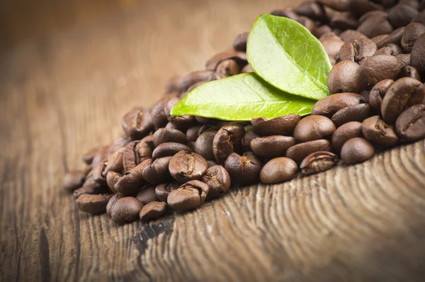 Granos de café sobre mesa de madera — Foto de Stock