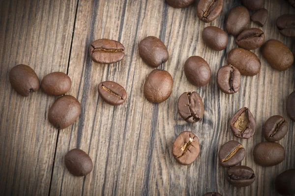 Granos de café sobre mesa de madera — Foto de Stock