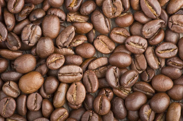 Granos de café sobre mesa de madera — Foto de Stock