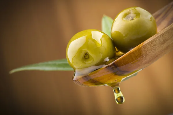 Оливки с маслом на деревянной ложке — стоковое фото
