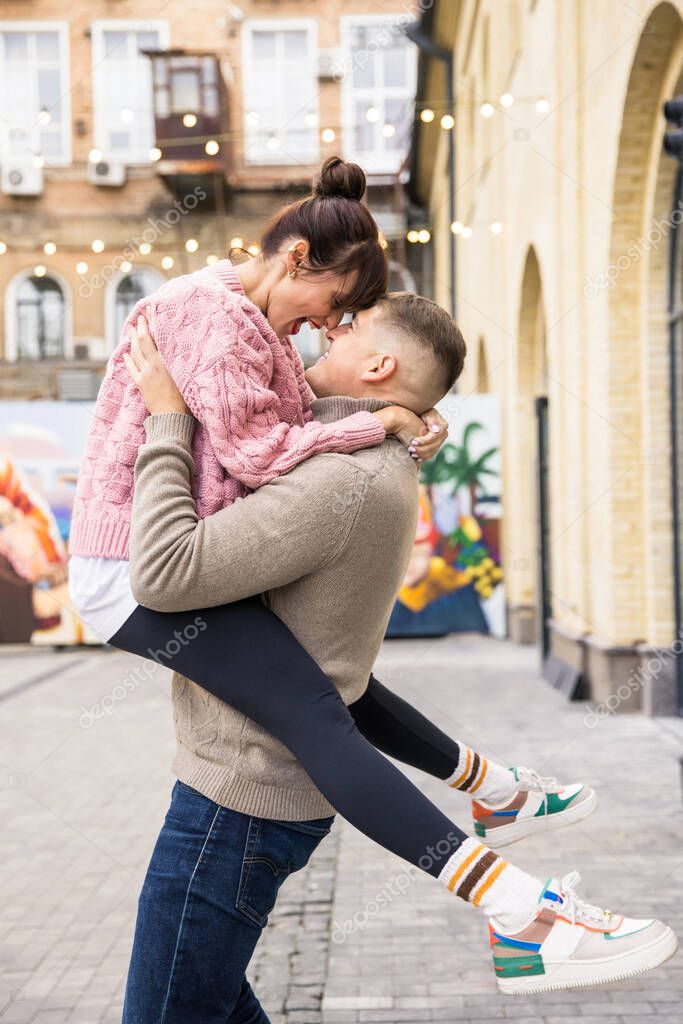 young couple in love hugging and kissing on the street