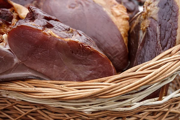 Pork ham placed in a wicker basket — Stock Photo, Image