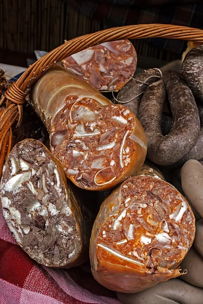 Traditional bio sausages in wicker basket — Stock Photo, Image