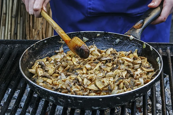 Cozinha cogumelos em uma panela na grelha — Fotografia de Stock