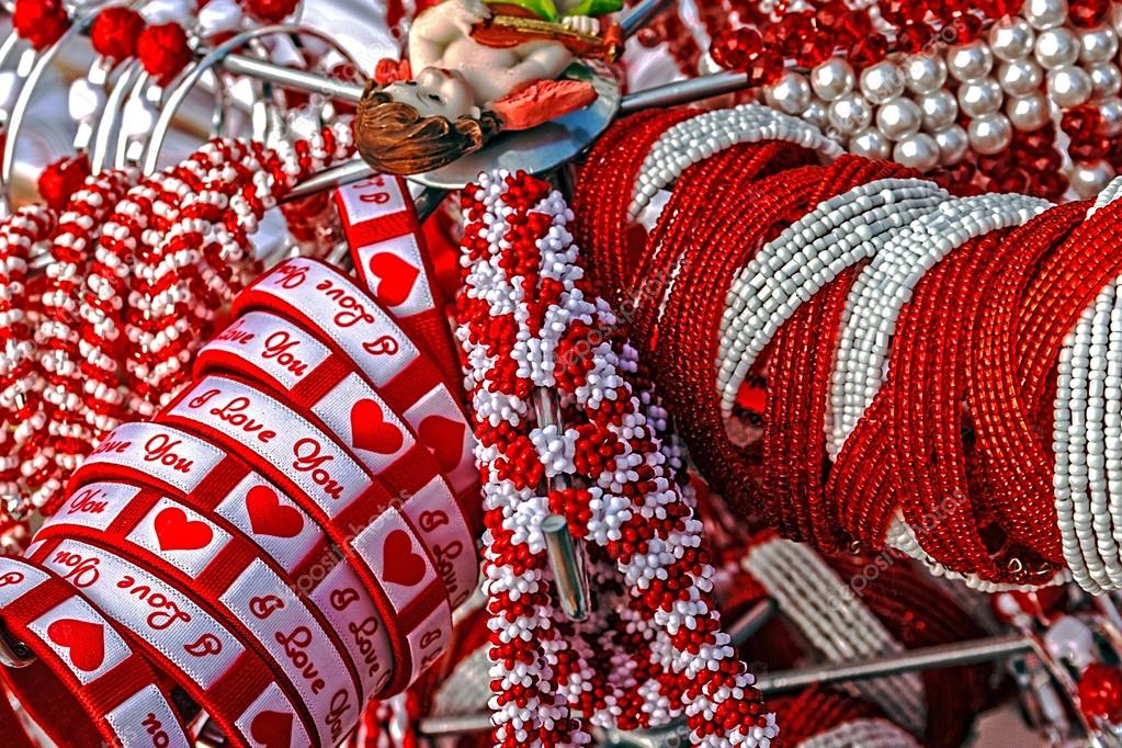 Bracelets with love logos, beads and necklaces in white and red, displayed on a stand. Symbolizes the arrival of spring.