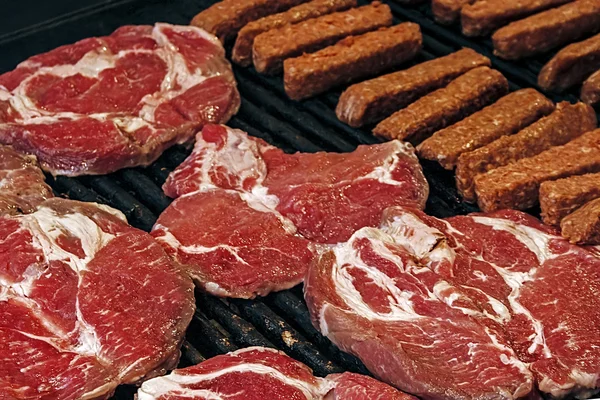 Salsicce rumene e carne rossa su una griglia-2 — Foto Stock