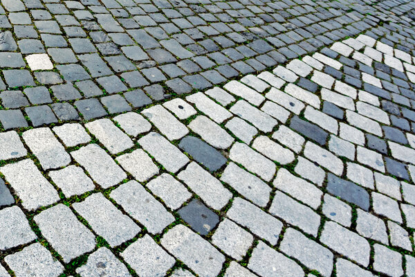 Detail of cobblestone sidewalk made of cubic stones.