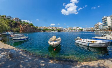 Agios Nikolaos, Girit, Yunanistan - 24 Temmuz 2021: Voulismeni Gölü. 1907 'de Fransız ordusu tarafından kazılan bir kanalla kasabanın limanına bağlandı. Efsaneye göre, Tanrıça Athena onunla yıkanmış..