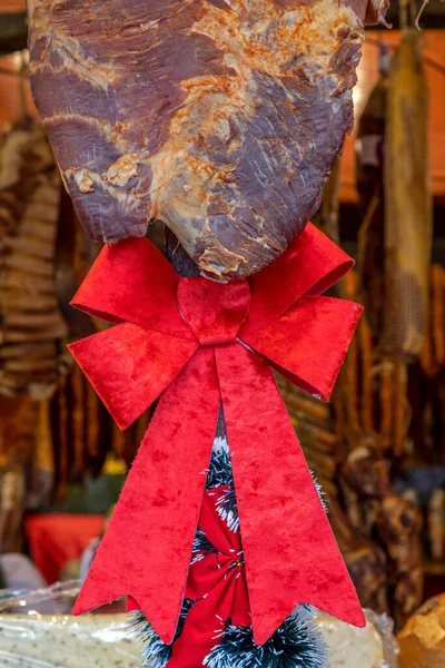 ルーマニアのハムは赤いリボンで飾られ 燻製と乾燥させ 伝統的な通りのクリスマスフェアで販売されます ルーマニアのマリアムール地域に特有の — ストック写真