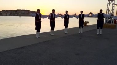 RETHYMNO, CRETE, GREECE - 17 Haziran 2021: Geleneksel kostümlü Yunan dansçılar Port Rethymno-Rethymno Marina 'da günbatımında halk dansı yaptılar.