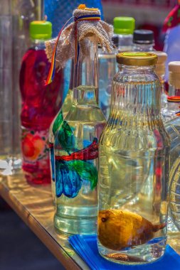 SAPANTA, MARAMURES, ROMANIA - 18 Eylül 2020: Geleneksel Romanya içkisi (Tuica ve Palinca) özel motiflerle süslenmiş ve bir sokak fuarında satılığa çıkarılmış resimlerle.