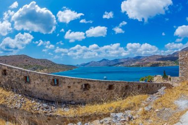 Spinalonga kalelerinden Mirabello Körfezi manzarası. Ada Girit Körfezi 'nde, Plaka kasabasının yanındaki Lasithi' de. 1579 yılında Venedikliler tarafından güçlendirilmiş bir cüzzamlı kolonisi olarak kullanıldı..