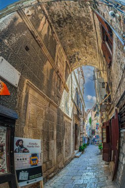 KORCULA, CROATIA - AUGUST 17, 2022: Narrow streets with tourist attractions and picturesque souvenir shops located on the historical center of the city. Birthplace of famous navigator Marco Polo.