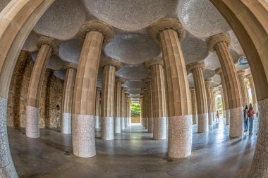 BARCELONA, SPAIN - 28 Şubat 2022: The Hypostyle Hall of the Hundred Columns, 86 sütun ile Antoni Gaudi tarafından tasarlanan Parc Guell 'in merkez terasını destekliyor. UNESCO Dünya Mirası Alanı