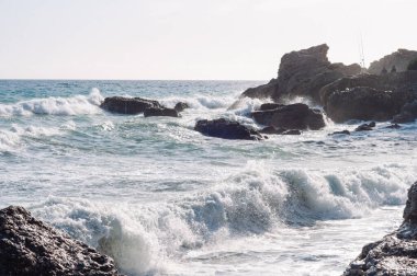 Gün batımı. Vahşi kaya plajı. Doğal kaya oluşumu..