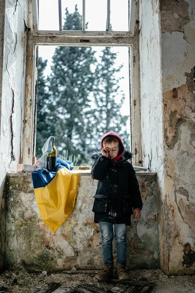 Ukrayna bayrağında Harabe Ev Savaşında Küçük Çocuk