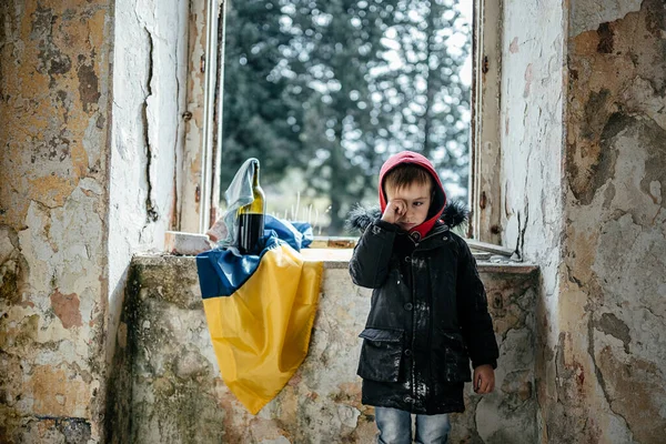 Ukrayna bayrağında Harabe Ev Savaşında Küçük Çocuk