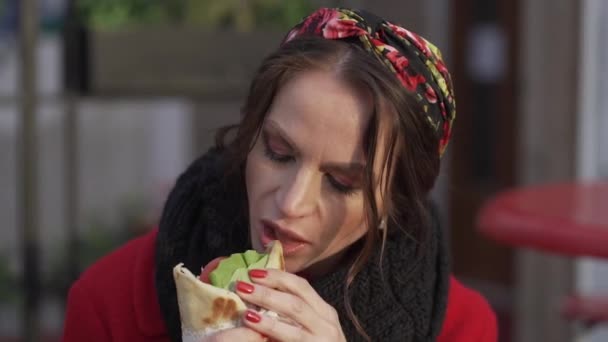 Молодая девушка ест шаурма гирос крупным планом — стоковое видео