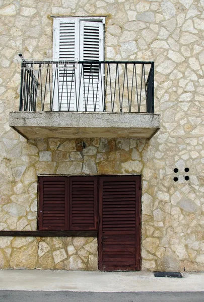 Old wooden door and shutters in stone house — Stock Photo, Image